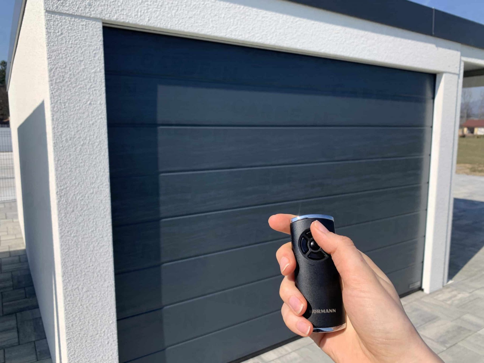 Ovládač Hormann pred garážovou bránou