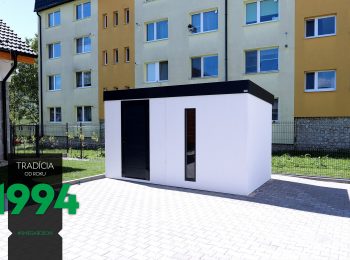 Panelák v pozadí bieleho záhradného domčeka
