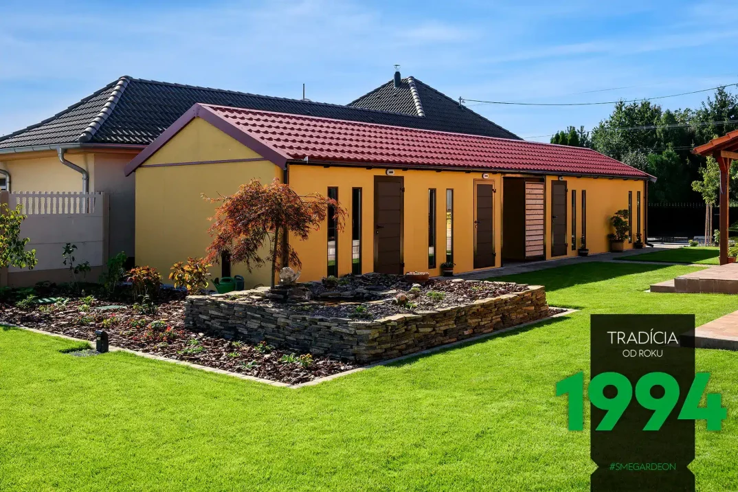 Atypická montovaná garáž v žluté omítce s hnědými doplňky a špičatou střechou