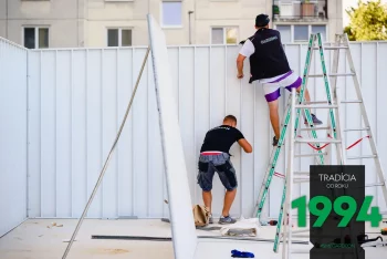 Montážnik na řebříku počas montáže