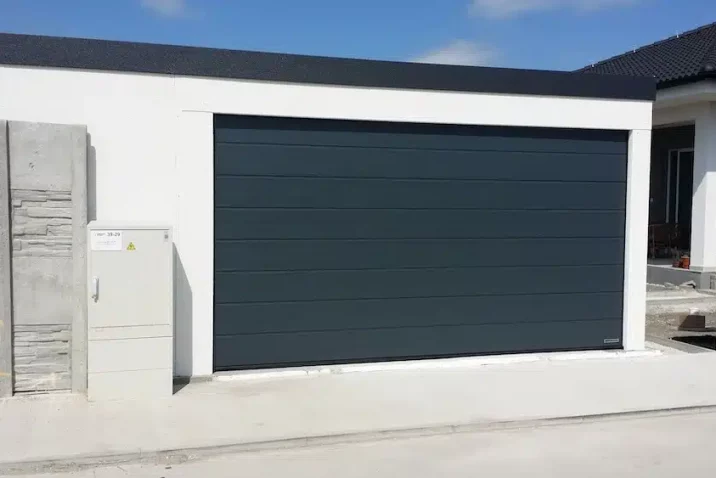 Garáž v bíle omítce a tmavou atikou