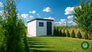 Bílý GARDEON zahradní domek obklopený stromky