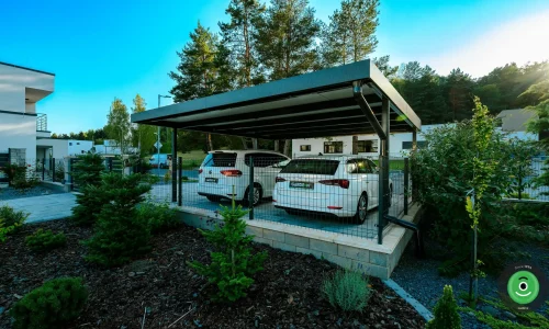 Přístřešek pro dvě auta obklopený zasazenými stromky