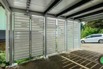 Detail na bílou kovovou výplň přístřešku pro dvě auta