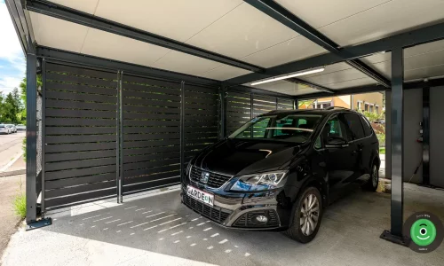 Černé auto v přístřešku s černou kovovou výplní