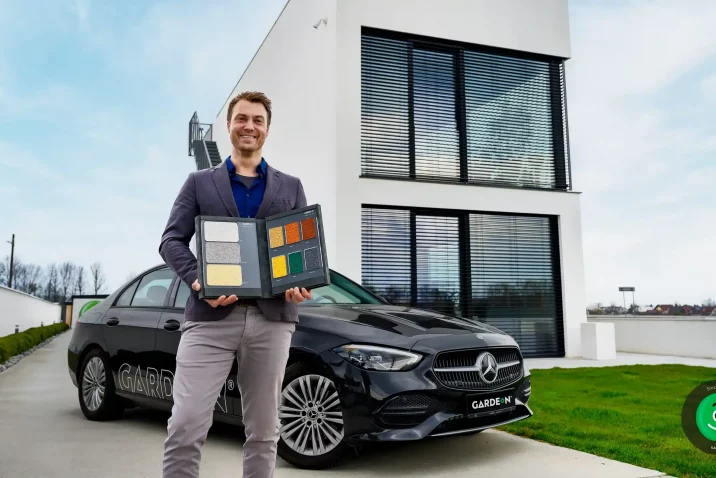 Obhlídkář stojí před autem a budovou GARDEON