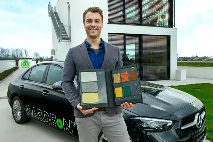 Obhlídkář stojí před autem a budovou GARDEON