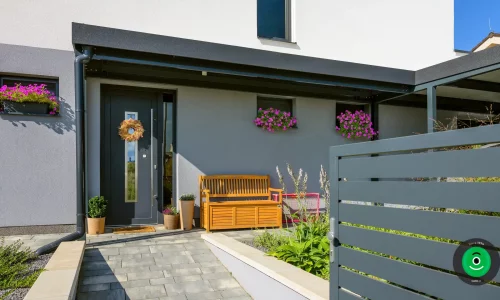 Malý přístřešek před dveřmi s dřevěnou lavičkou k sezení