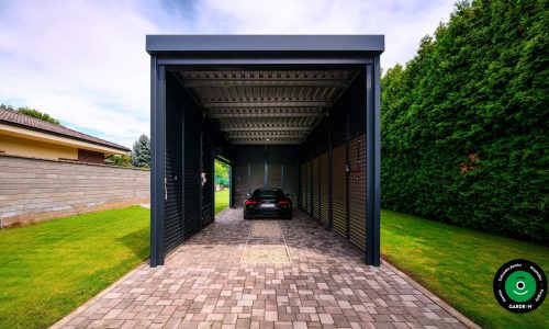 Moderní přístřešek s černým autem zaparkovaným uvnitř.