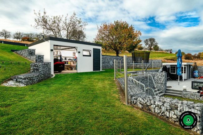 Otevřená garáž s uloženým nářadím a zahradní technikou uvnitř