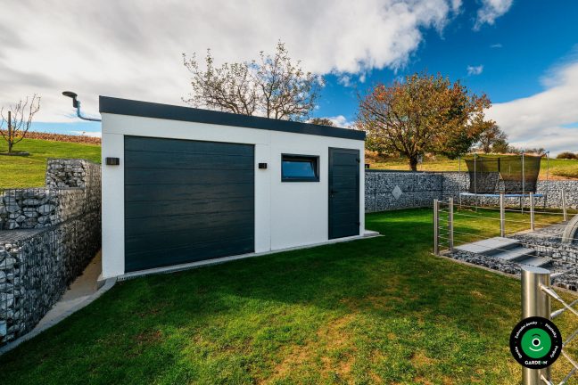 Garáž s pultovou střechou v upraveném zeleném a svažitém prostředí