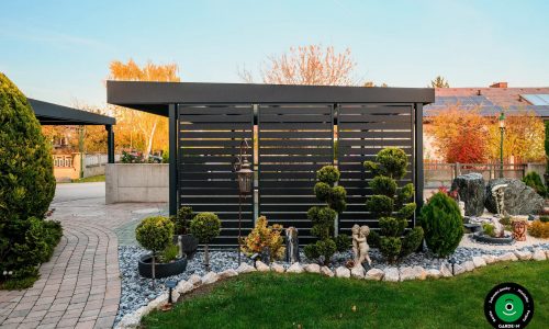 Boční stěna přístřešku u okrasných dřevin a kamínků