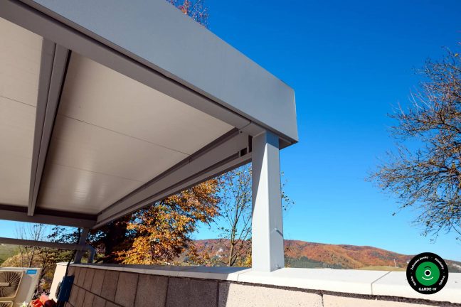 Dvojpřístřešek na auta zasazený do upravené venkovní plochy