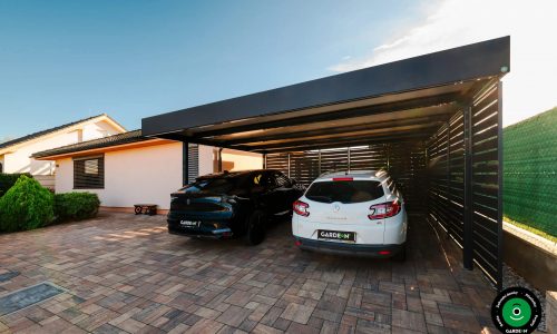 Přístřešek s černým a bílým autem chráněnými pod pevnou střechou