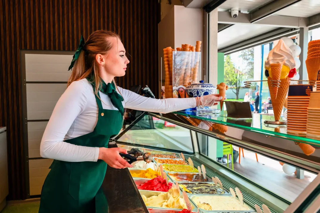 Obsluha připravující řemeslnou zmrzlinu v moderním gastro prostoru