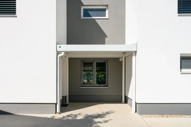 Praktický přístřešek u zahradního domku s čistým moderním designem