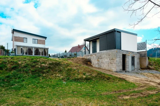 Praktický zahradní domek s krytým přístřeškem a moderní fasádou