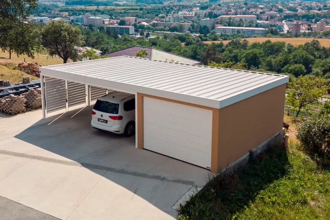 Cihlová omítka KABE na garáži s přístřeškem a bílou střechou.