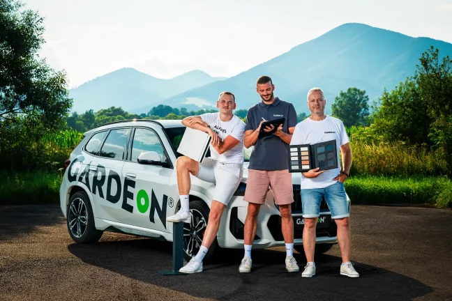 Tři obchodní agenti GARDEON se vzorníky před firemním autem.