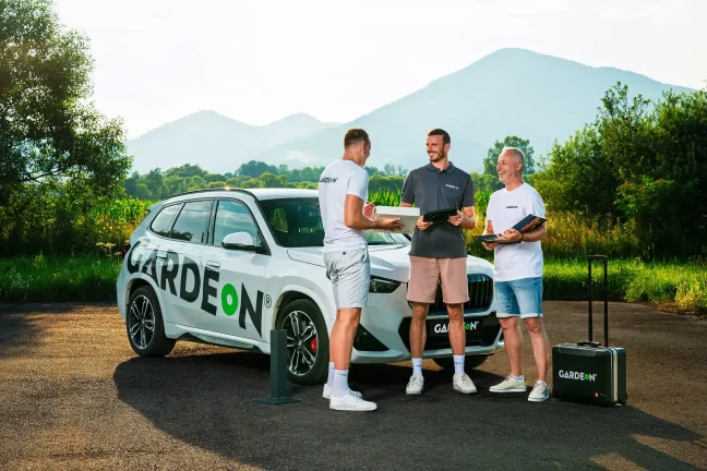 Setkání týmu GARDEON se vzorníky a kufříkem před značkovým BMW.