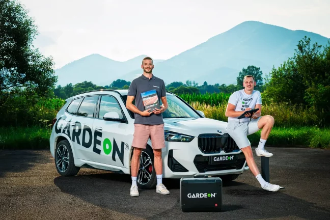 Dva zaměstnanci GARDEON s vzorníkem a tabletem před firemním BMW.