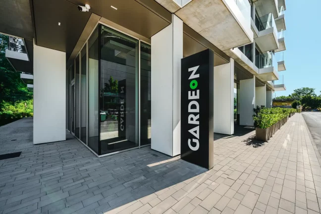 Detail vstupu s nápisem GARDEON před vstupem do pobočky