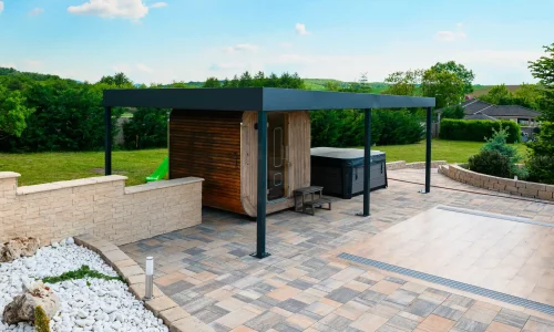 Antracitová pergola u bazénu s průhledným zastřešením, bílý štěrk a dlážděná plocha kolem