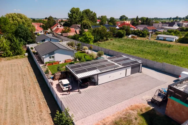 Letecký pohled na garáž se dvěma auty a chlapcem na dvoře