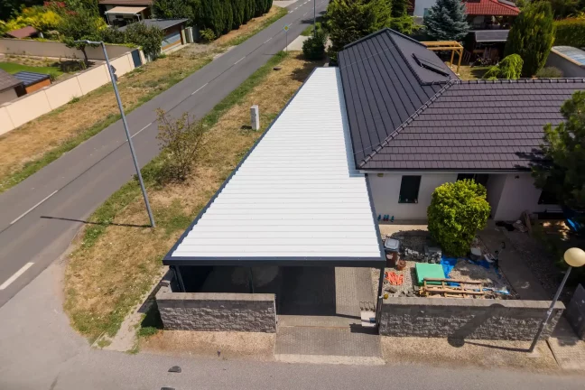 Letecký pohled na dlouhou bílou střechu garáže podél silnice