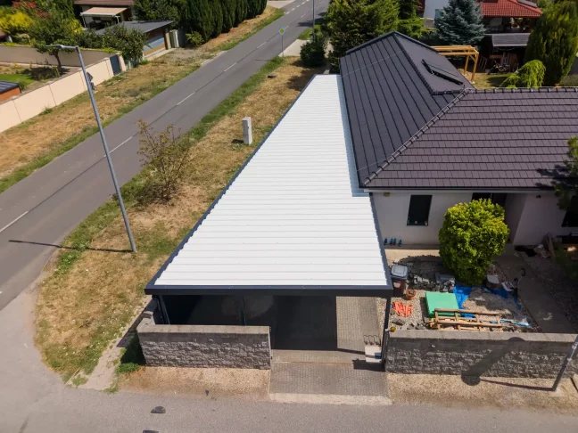 Letecký pohled na dlouhou bílou střechu garáže podél silnice
