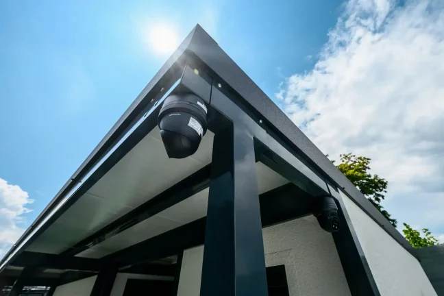 Detail dvou bezpečnostních kamer pod střechou domku