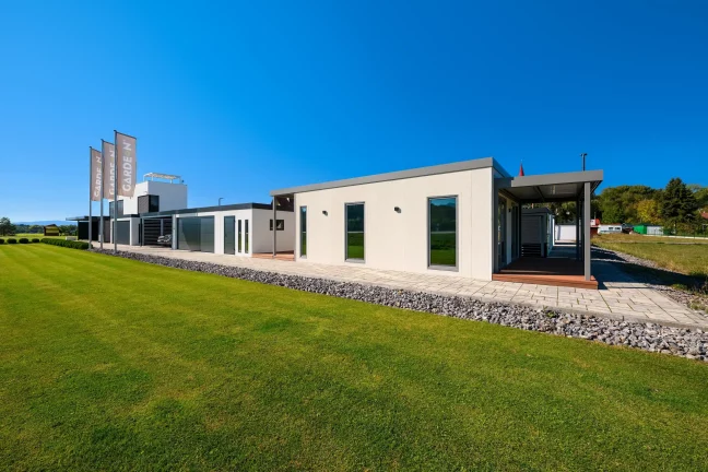 Tiny house v showroomu Gardeon z dálky, boční stěna s okny u trávníku