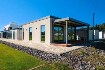 Přední roh tiny housu s krytou terasou a velkými prosklenými dveřmi