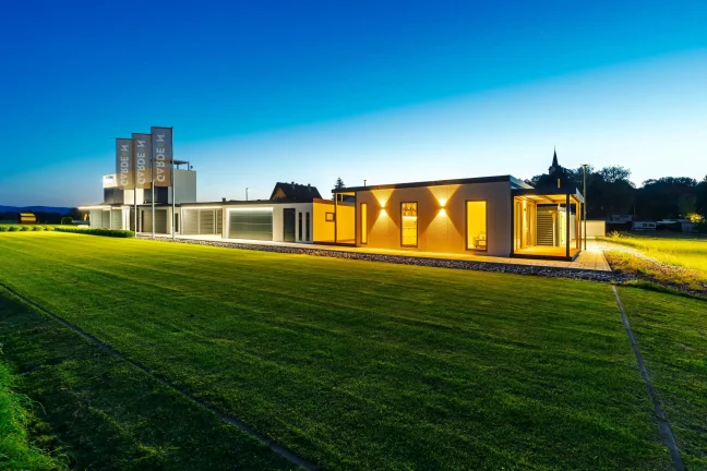 Večerní pohled na osvětlený showroom Gardeon s tiny housem
